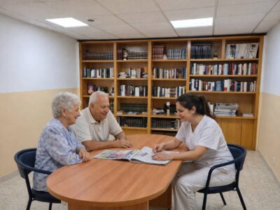 Personas mayores con Alzheimer compartiendo lectura acompañada en sala tranquila